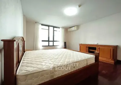 Spacious bedroom with wooden furniture and natural light