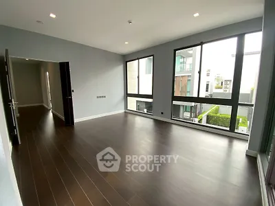 Spacious modern living room with large windows and hardwood floors