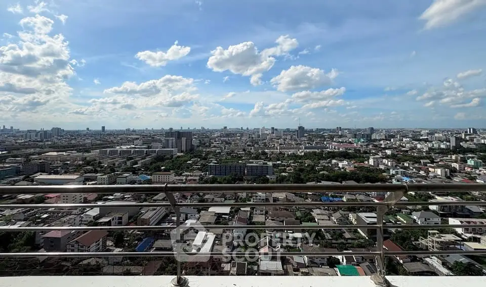 Stunning panoramic city view from a high-rise balcony with clear blue skies.