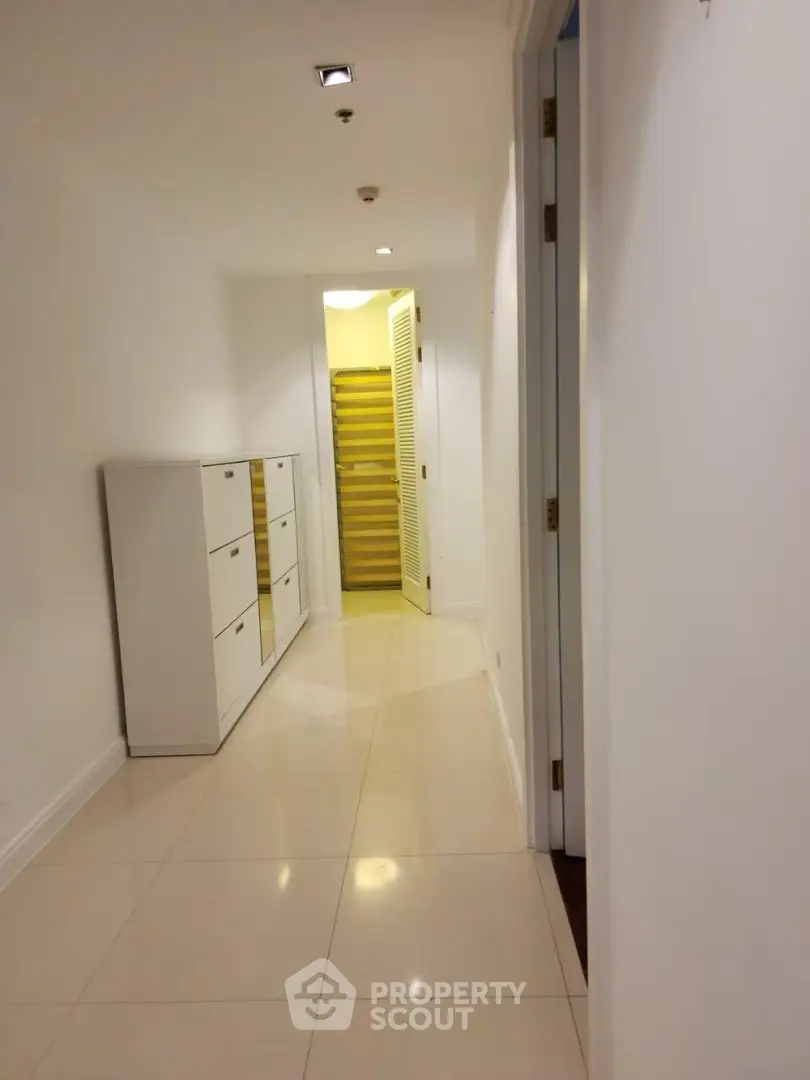 Bright hallway with sleek white cabinetry and modern tile flooring