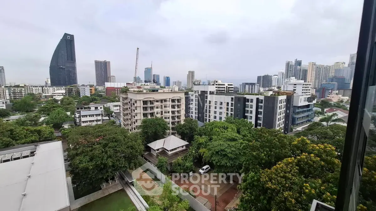 Stunning cityscape view from a high-rise apartment showcasing modern architecture and lush greenery.