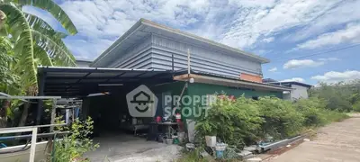 Spacious industrial-style building with lush greenery and open parking area