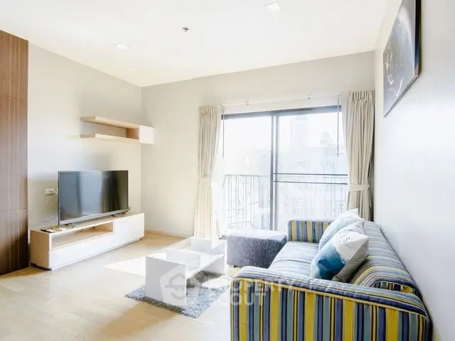 Bright and modern living room with striped sofa and large window view.