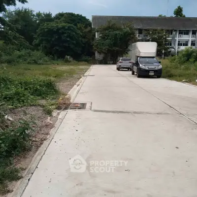 Quiet residential street with parked vehicles and lush greenery