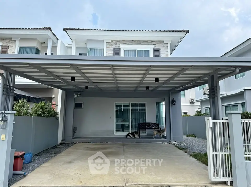 Modern two-story house with spacious carport and sleek exterior design.