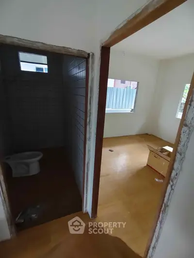 Unfinished interior with bathroom and adjacent room, showcasing renovation potential.