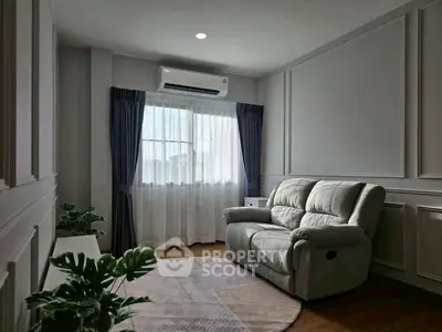 Cozy living room with plush sofa and air conditioning, perfect for relaxation.
