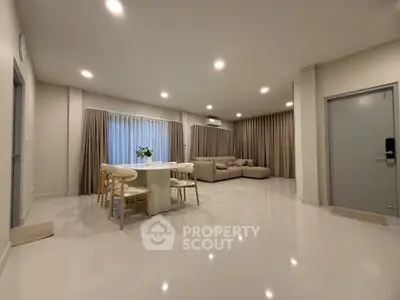 Spacious modern living room with elegant dining area and cozy seating, perfect for family gatherings.