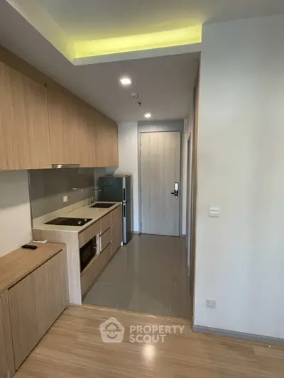 Modern compact kitchen with wooden cabinets and sleek appliances