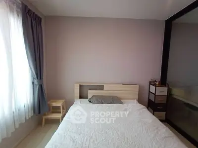 Cozy bedroom with natural light and modern furnishings, perfect for relaxation and comfort.