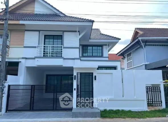 Modern two-story house with sleek design and gated entrance in a suburban neighborhood.