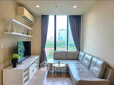 Modern living room with large window and city view, featuring sleek furniture and minimalist decor.