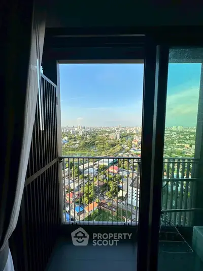 Stunning high-rise balcony view showcasing expansive cityscape and clear blue skies.