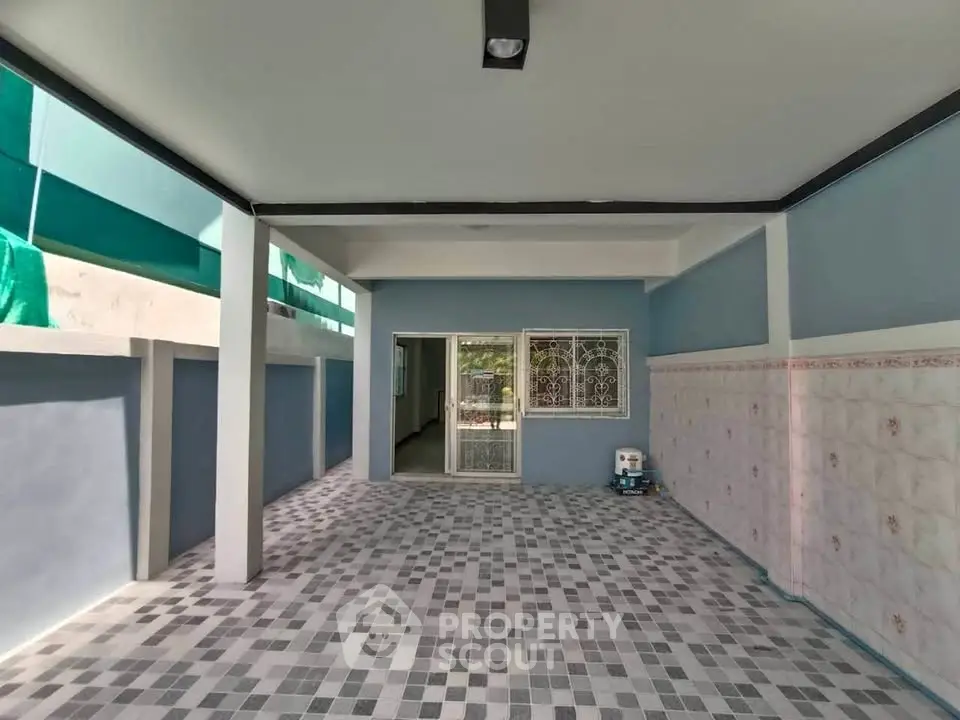 Spacious tiled patio with covered roof and sliding glass door entrance