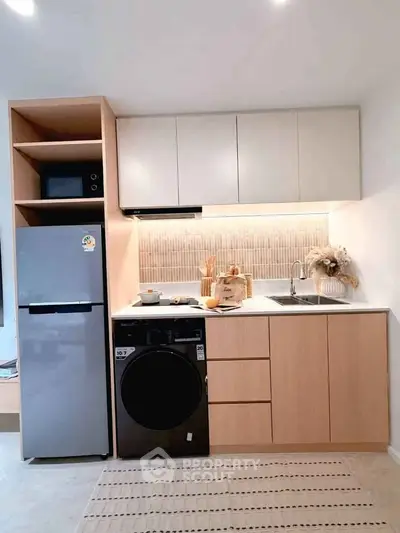 Modern kitchen with sleek appliances and stylish cabinetry in a compact layout.