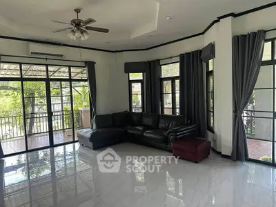 Spacious living room with large windows and modern furnishings, perfect for relaxation.
