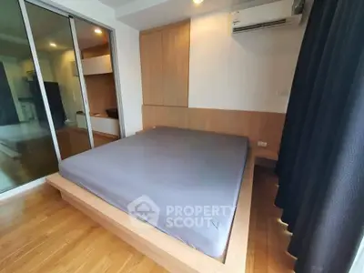 Modern bedroom with wooden flooring and built-in wardrobe in a stylish apartment.