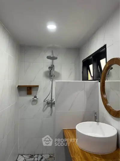 Modern bathroom with sleek shower and stylish round mirror