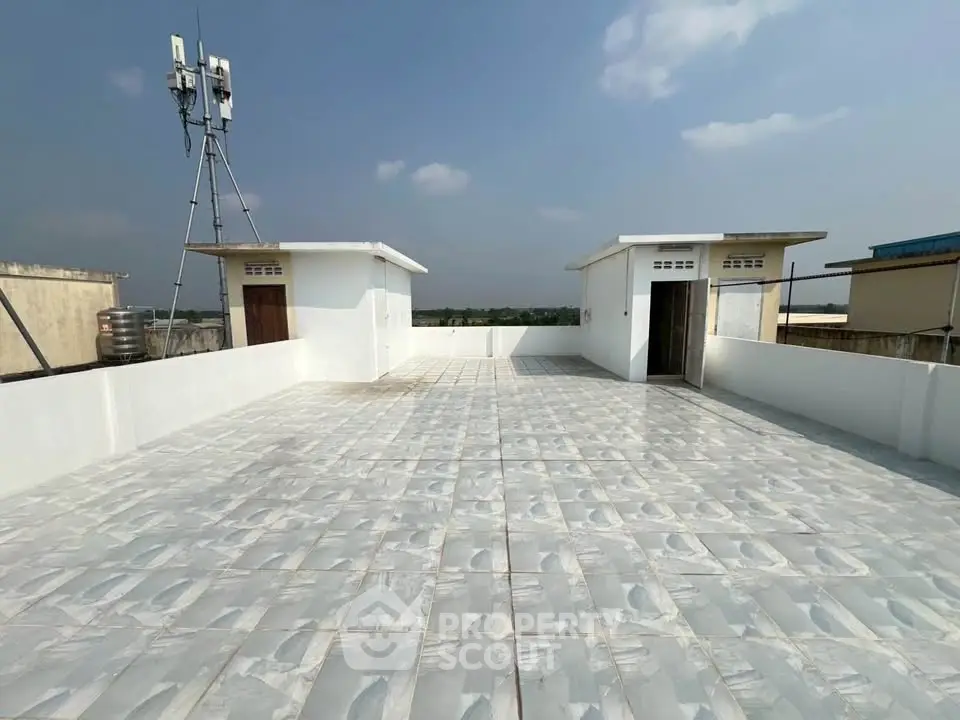 Spacious rooftop with tiled flooring and clear sky view, ideal for gatherings or relaxation.