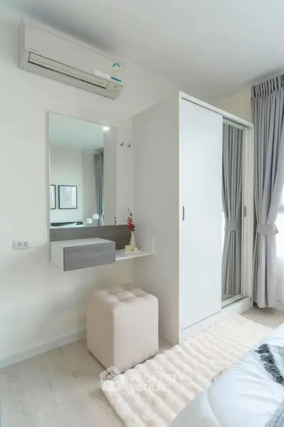 Modern bedroom with sleek wardrobe and air conditioning, featuring elegant curtains and cozy decor.