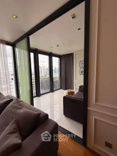 Spacious modern living room with large windows and city view, featuring elegant decor and cozy seating.