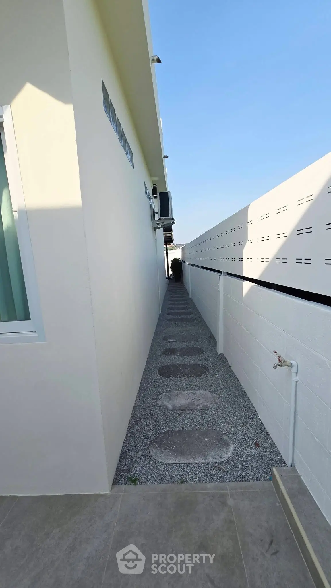 Narrow exterior pathway with modern design and minimalist landscaping