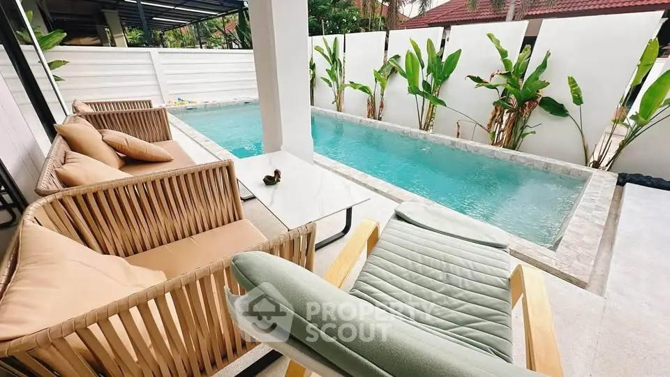 Luxurious outdoor pool area with stylish seating and lush greenery, perfect for relaxation and entertainment.