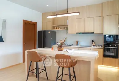 Modern kitchen with island, sleek cabinetry, and built-in appliances for a stylish culinary experience.