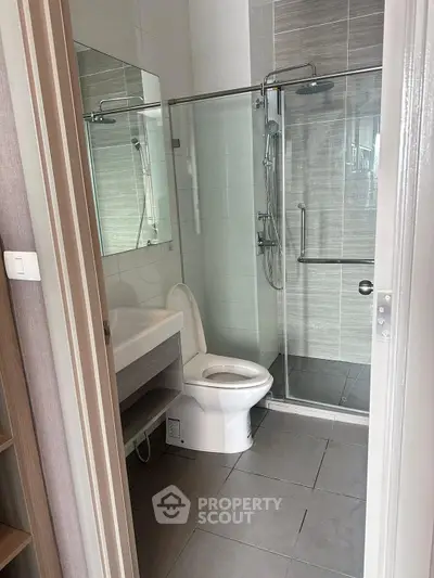 Modern bathroom with glass shower and sleek fixtures in a contemporary apartment.