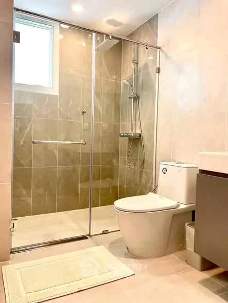 Modern bathroom with glass shower enclosure and sleek fixtures.