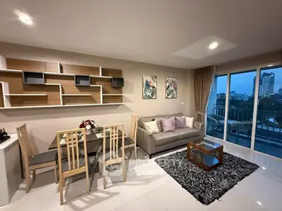 Modern living room with stylish decor and city view, featuring a cozy sofa and elegant dining area.