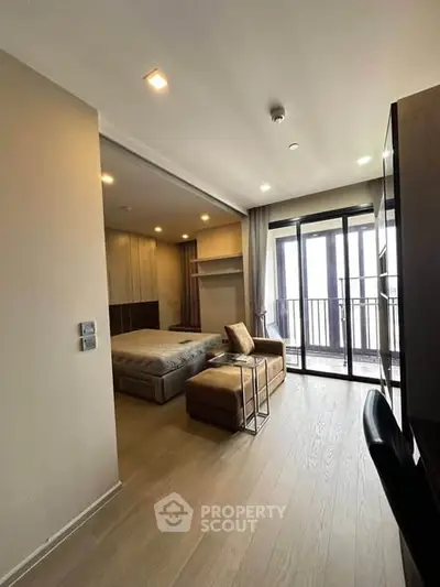 Modern bedroom with balcony access and stylish furnishings in a high-rise apartment.