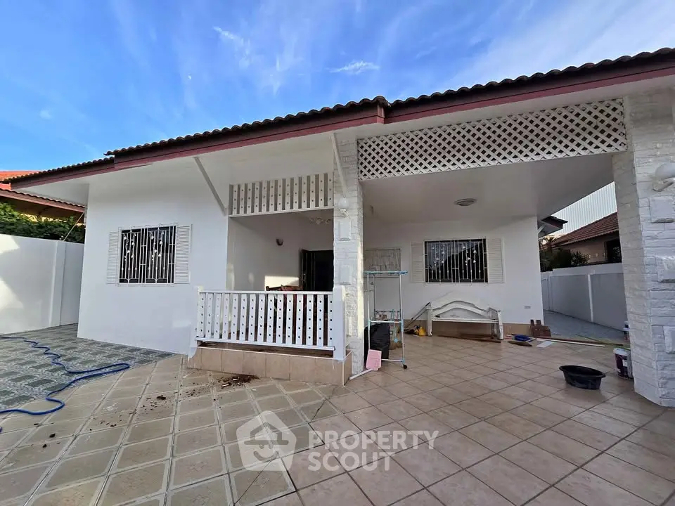 Charming single-story home with spacious tiled patio and white lattice accents.