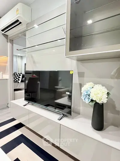 Modern living room with sleek TV unit and stylish decor in a contemporary apartment.