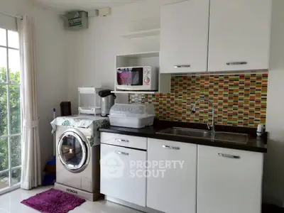 Modern kitchen with washing machine and colorful backsplash