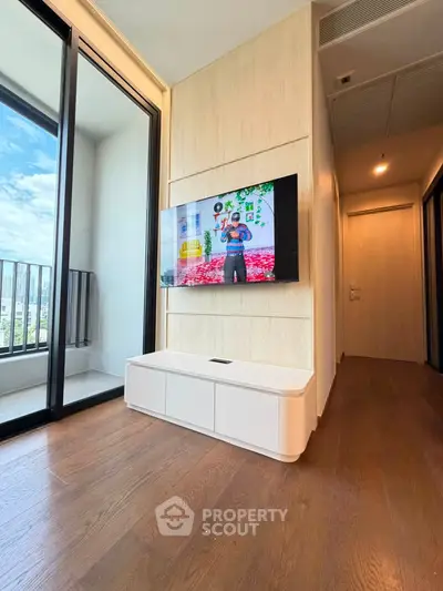 Modern living room with wall-mounted TV and balcony view in a stylish apartment.
