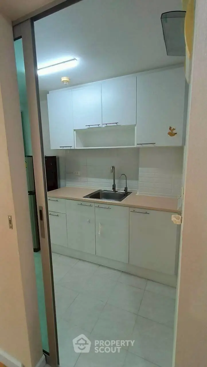 Modern kitchen with sleek white cabinets and stainless steel sink