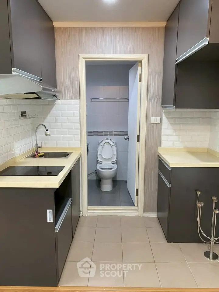 Compact kitchen with dual sinks and open view to adjacent bathroom