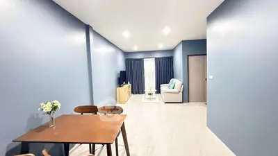 Spacious modern living room with elegant blue walls and cozy seating area