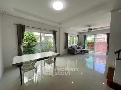 Spacious living room with large windows and garden view, perfect for family gatherings.