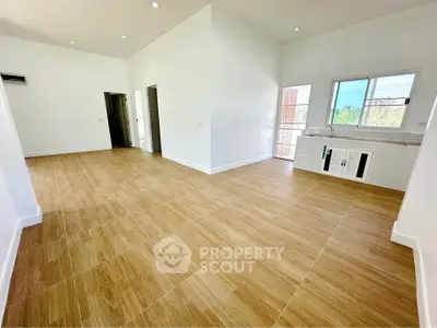 Spacious open-plan living area with modern kitchen and wooden flooring