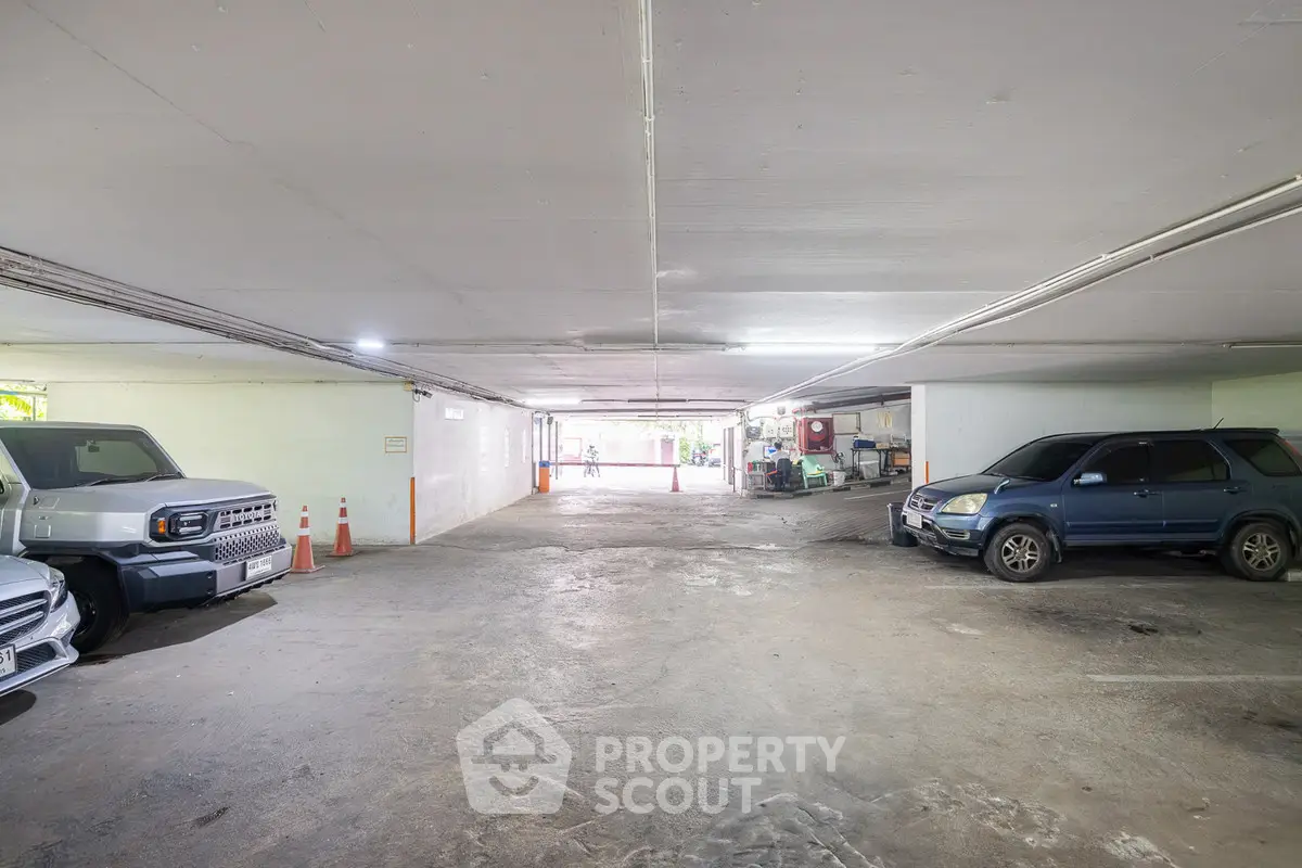 Spacious indoor parking area with multiple vehicles and ample lighting.