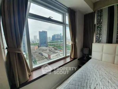 Modern bedroom with large window offering stunning city view in high-rise apartment.