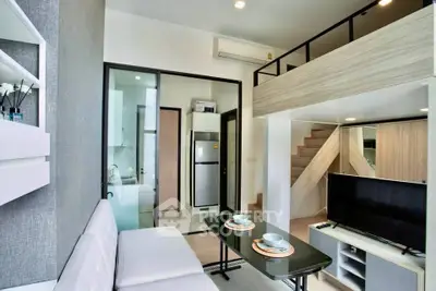 Modern loft-style living room with mezzanine, sleek furniture, and open kitchen layout.