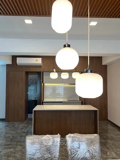Modern kitchen with stylish pendant lights and sleek wooden cabinetry