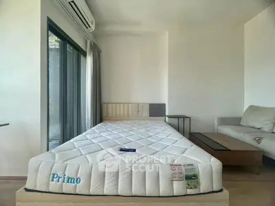 Modern bedroom with minimalist design and large window for natural light.