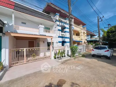 Charming townhouse exterior with gated entrance and vibrant facade in a serene neighborhood.