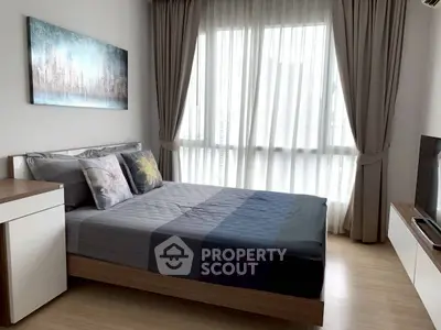 Modern bedroom with large window and stylish decor in a contemporary apartment.
