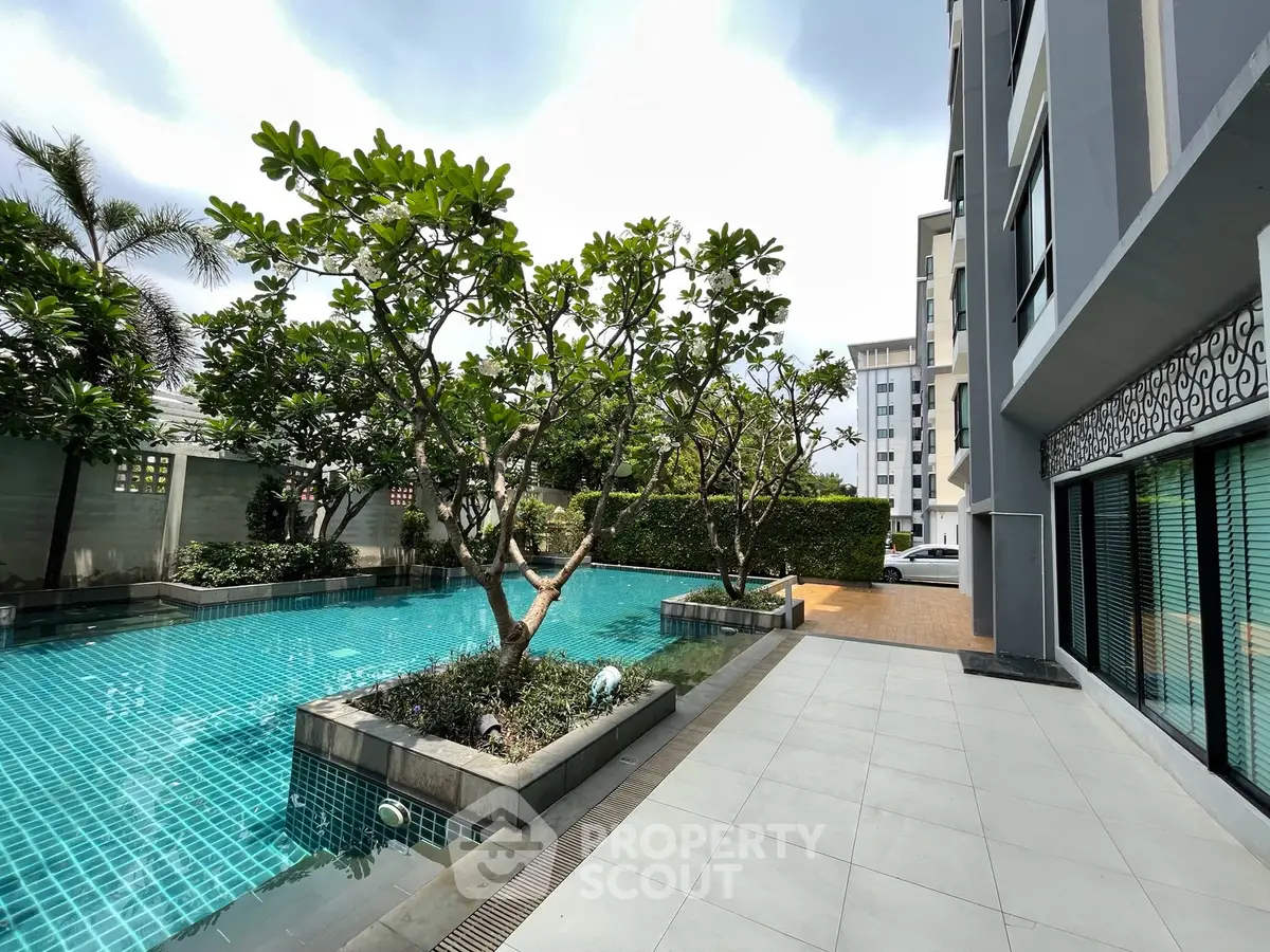 Luxurious apartment poolside with lush greenery and modern architecture