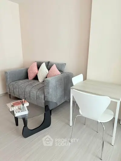 Modern living room with stylish gray sofa and sleek white dining table, perfect for urban living.